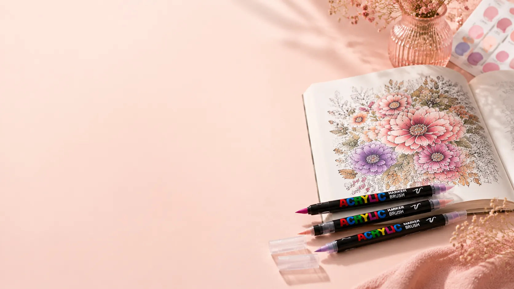 Scène douce et féminine représentant un carnet de coloriage ouvert, entouré de feutres acryliques et d'un vase avec des fleurs sèches sur un bureau pastel, créant une ambiance créative et inspirante.